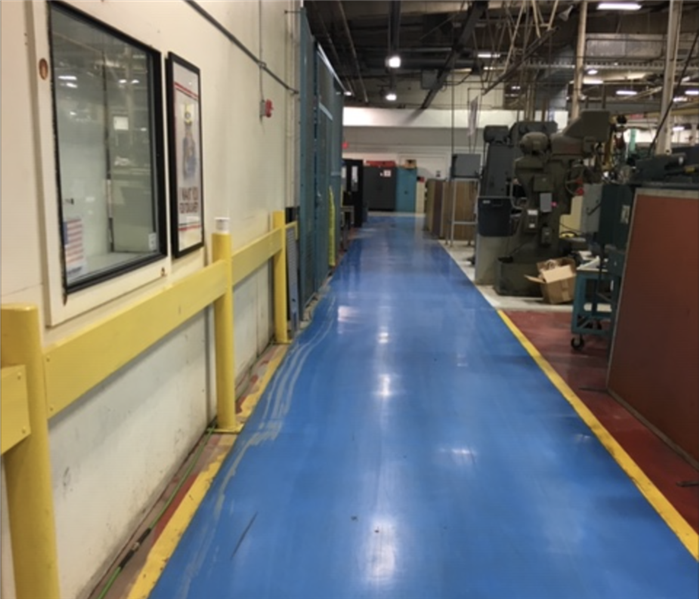 Commercial warehouse facility with dry blue flooring after water was extracted.